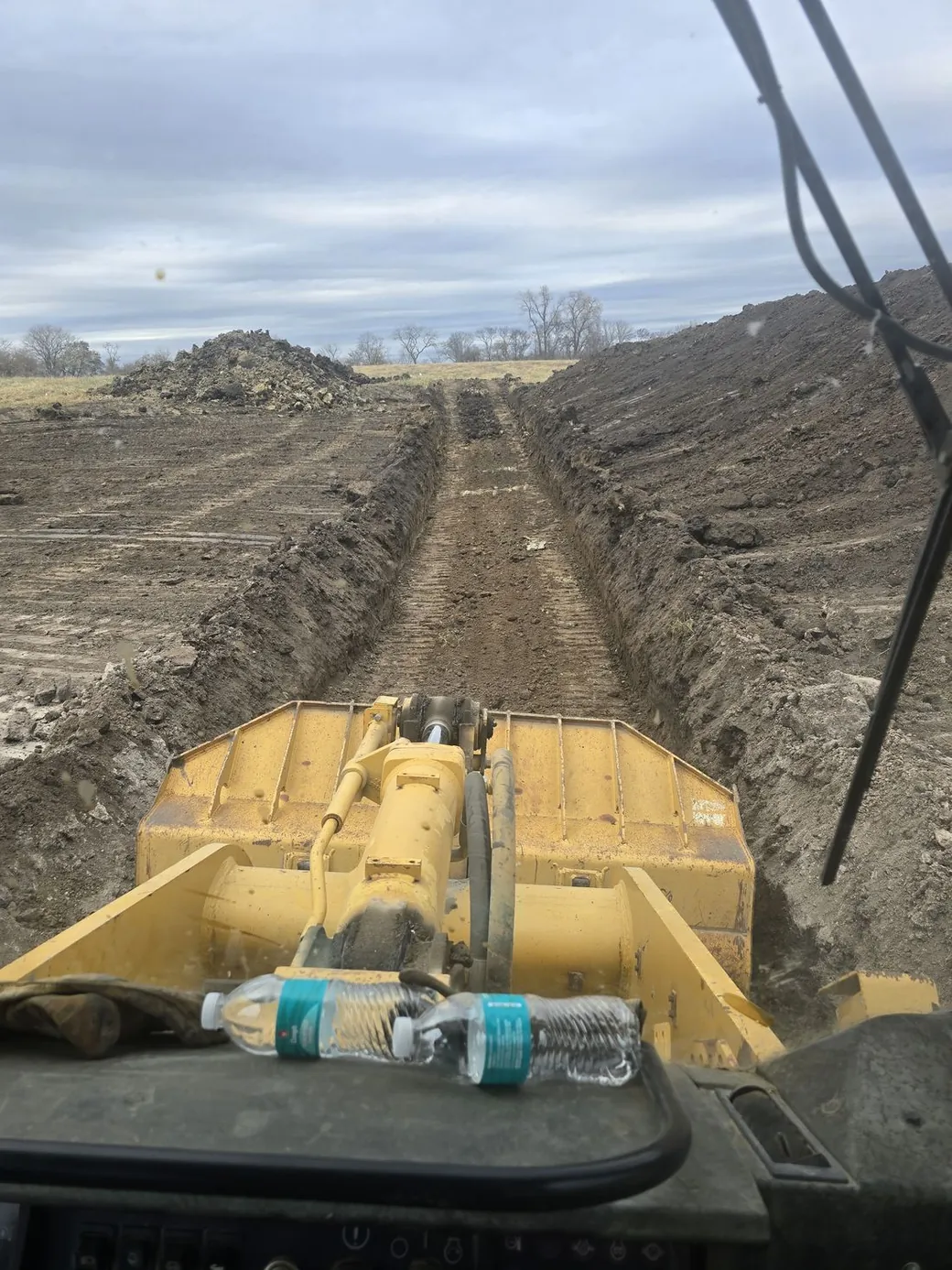 The view from the cab of a dozer looking down a freshly cut trench line