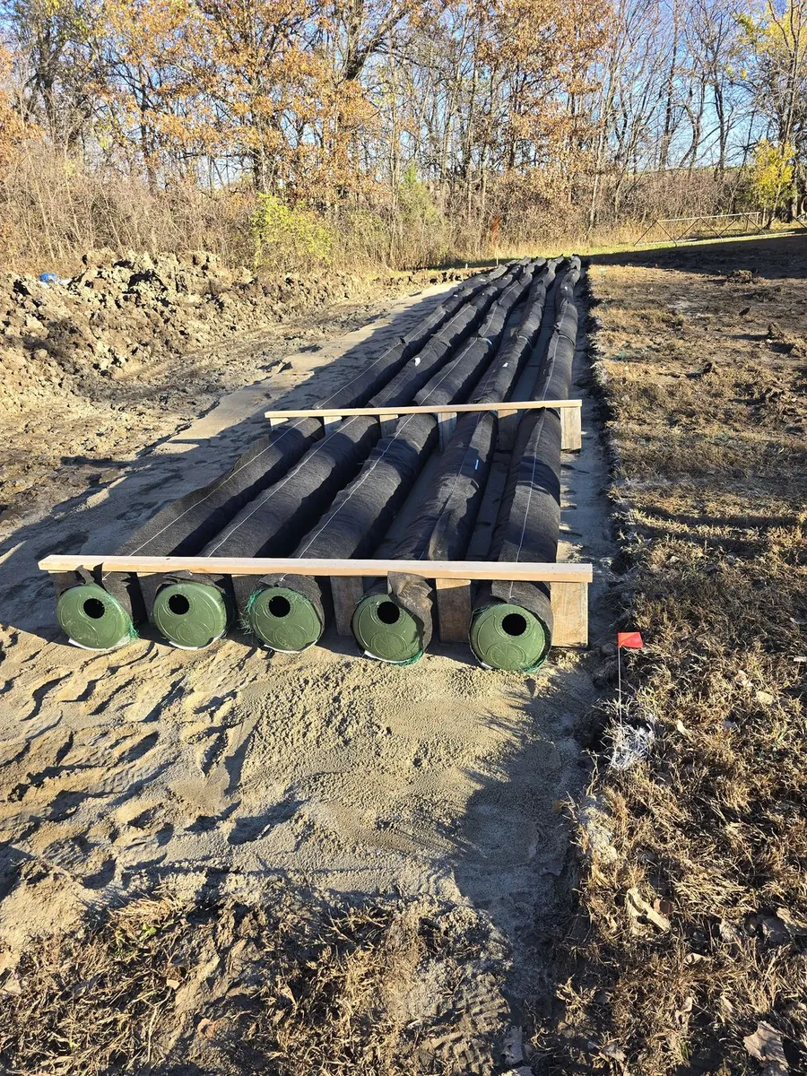 A row of drainage pipe laid out on a sand bed for a septic install