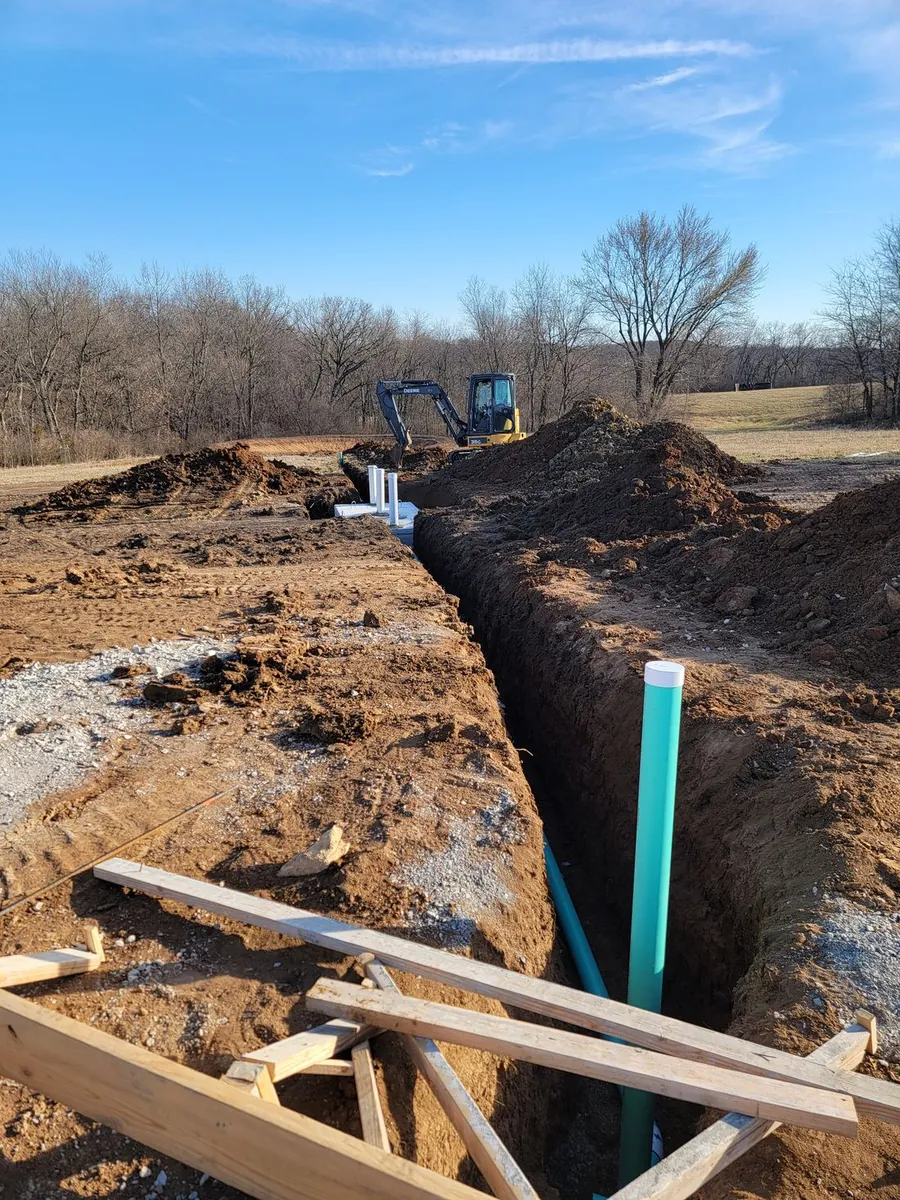 A crisp utility trench with new sewer pipe run out to a foundation